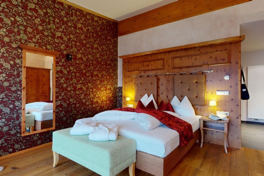 Junior suite apartment with bed and mirror overlooking the hallway