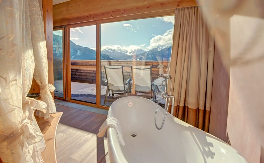 Romantisk suite med fritstående badekar og balkon med udsigt over bjergene